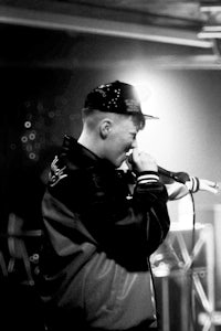 a black and white photo of a man singing into a microphone